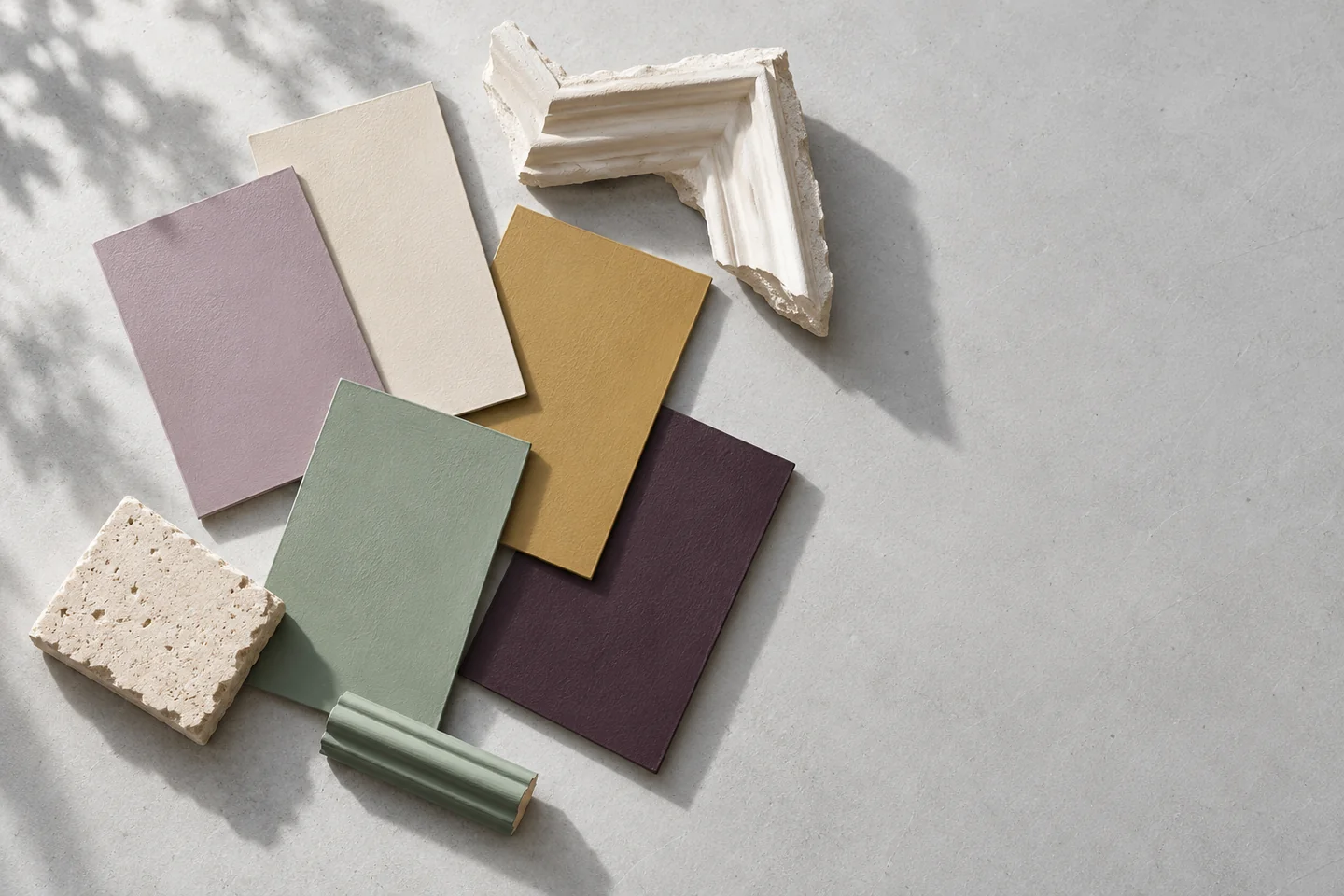Rectangular colour samples beside limestone, a plaster cornice fragment and painted timber